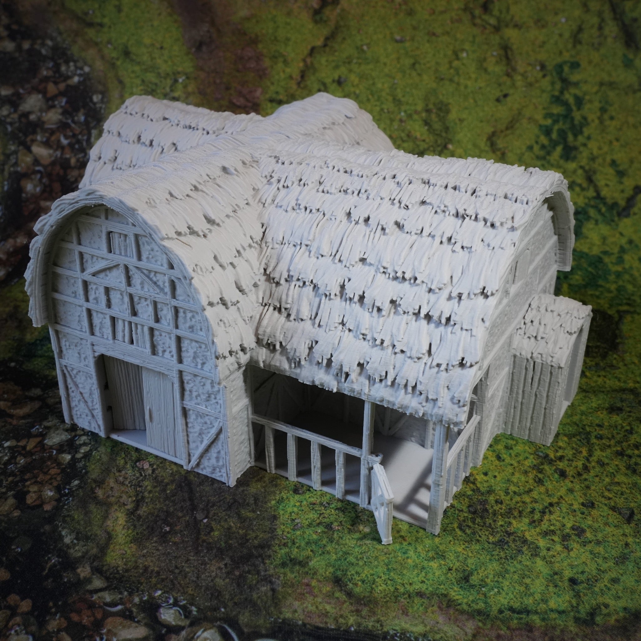 Weißer Miniatur-Pferdestall mit Strohdach und Gittertor, detailreich gefertigt.