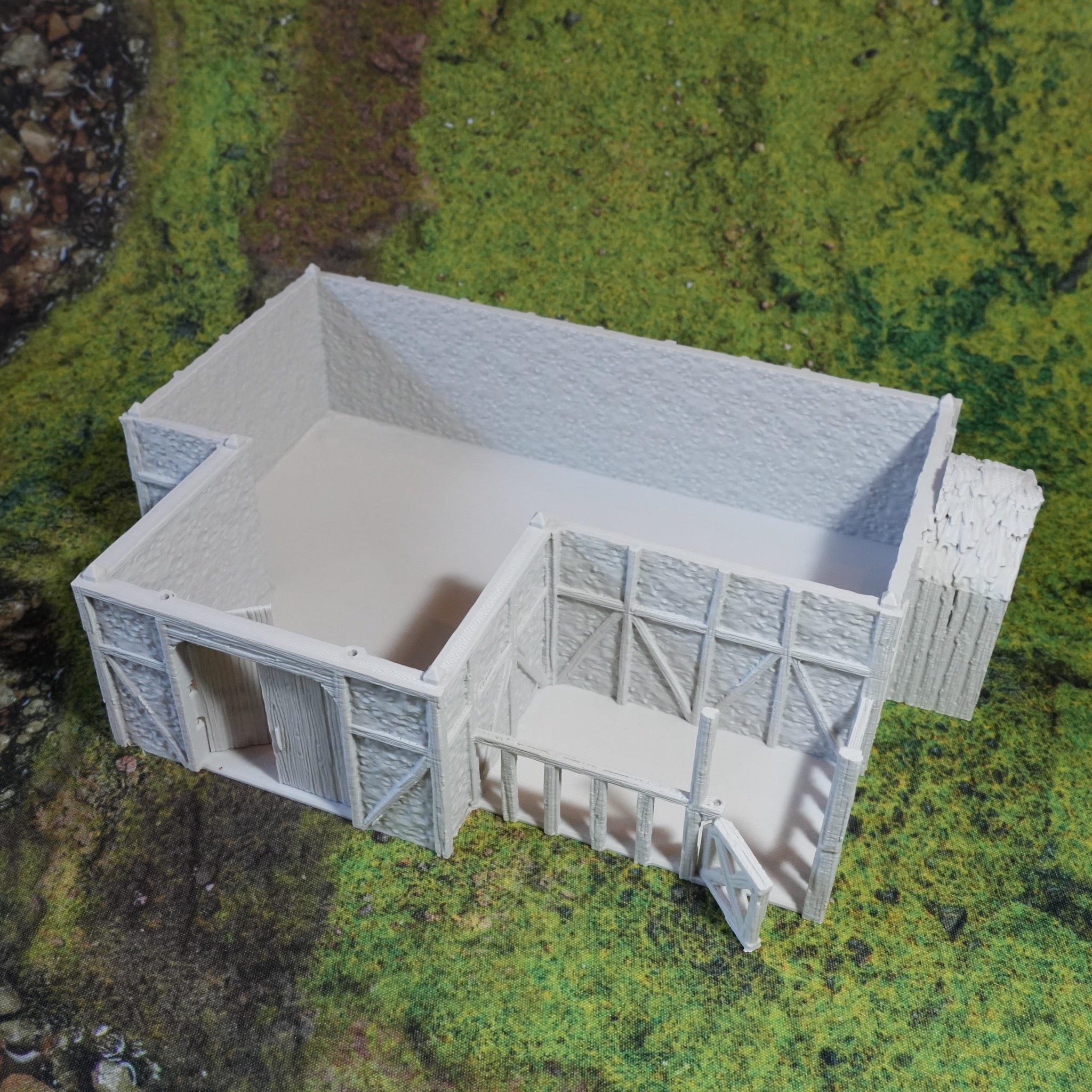 Weißer moderner Pferdestall aus Kunststoff mit offenem Design und eingezäuntem Bereich auf grünem Untergrund.