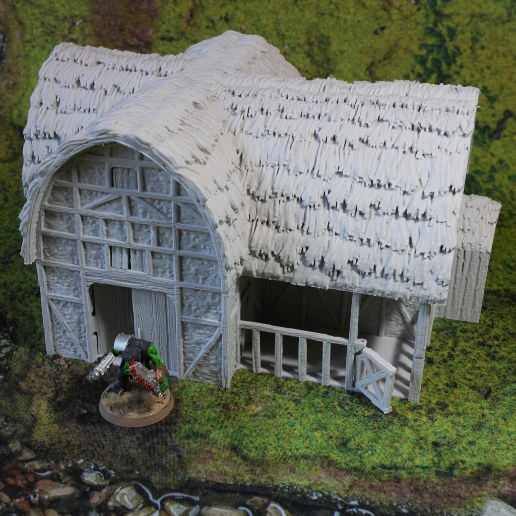 Weißer Pferdestall mit Strohdach und großen Toren auf grünem Diorama-Grund.