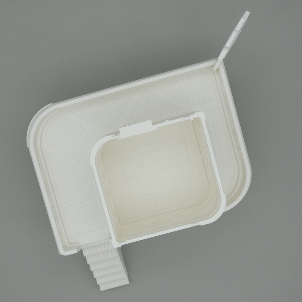 Weißes, minimalistisches Modell eines modernen Gebäudes mit rechteckigem Innenhof und Außentreppe.