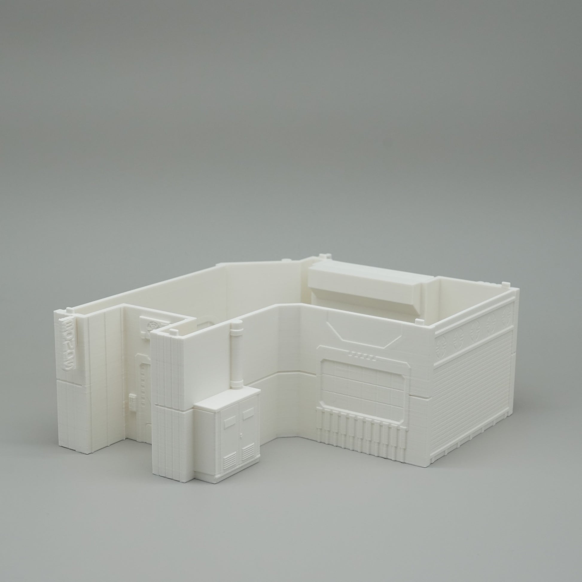 Weißes minimalistisches Modell eines Hauses mit rechteckigen und quadratischen Formen auf grauem Hintergrund.