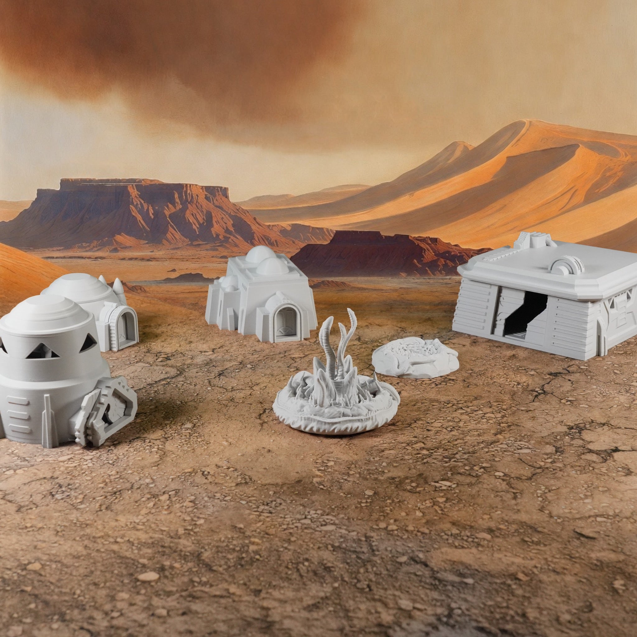 Weiße 28mm Wüstenmodule mit Haus, Getreidesilo, Bunker, Beobachtungsturm und Sandwürmern vor Wüstenlandschaft.