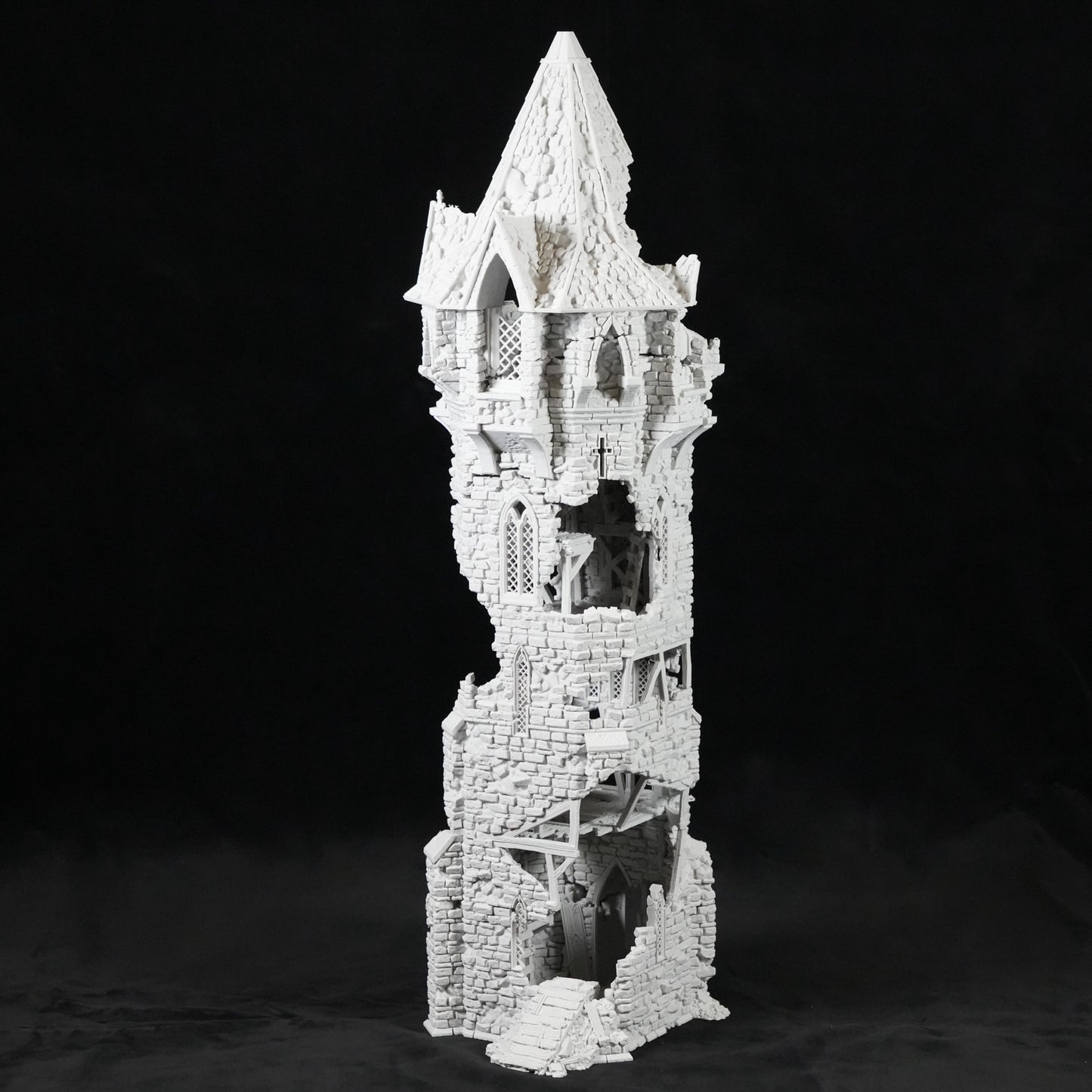 Weißer, schmaler, hoher Turm mit zerfallener, zerklüfteter Steinstruktur und mehreren offenen Fenstern.