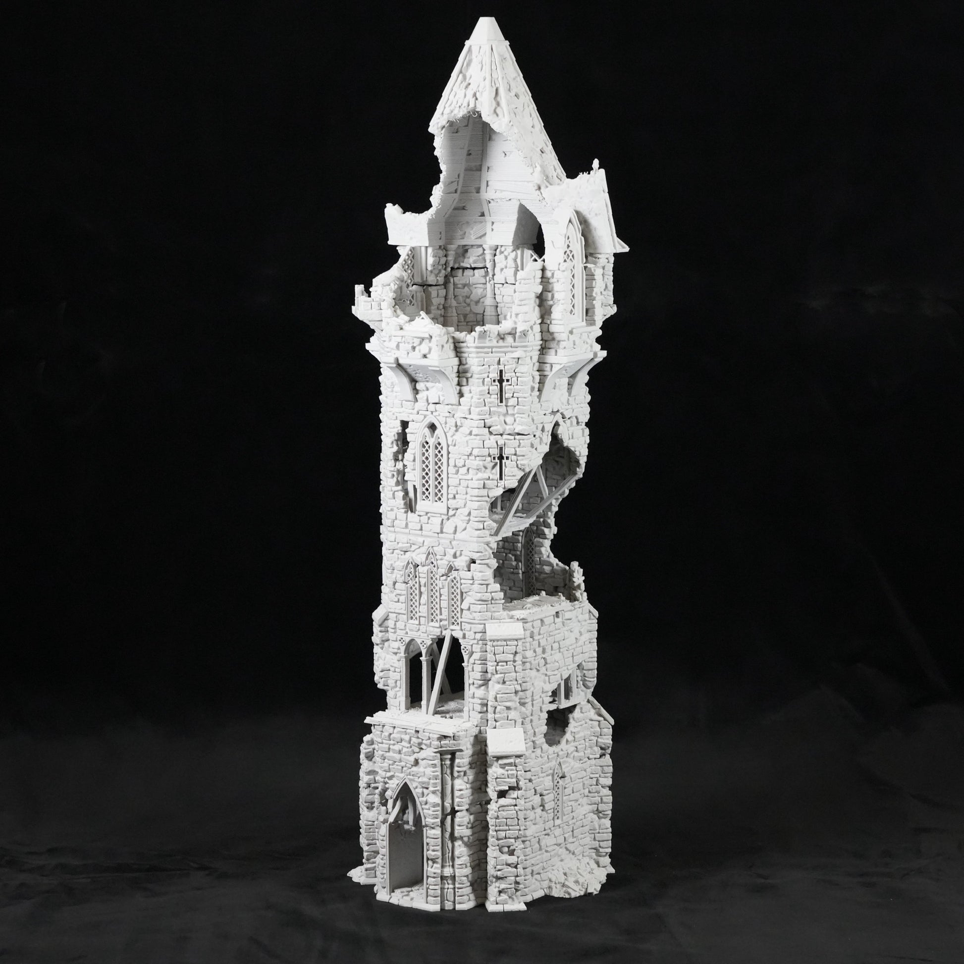 Hoher, schmaler grauer Turm mit zerfallenen, gotischen Mauern und scharfer Spitze aus Steinoptik.
