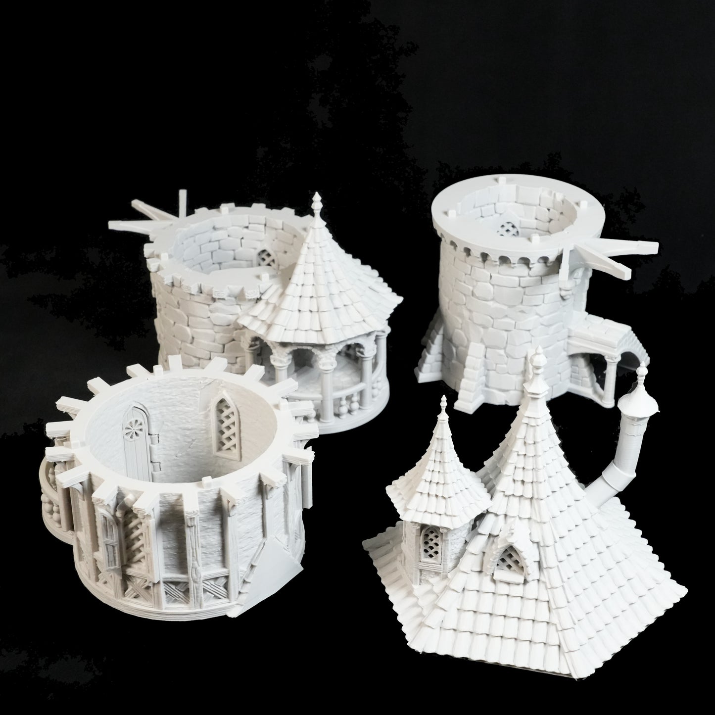 Vier unbemalte Zaubererturm-Miniaturen von Nebelstein Prints bieten Steintexturen, Bogenfenster und mittelalterliche Details - ideal für Fantasy-Tabletop-Setups. Sie sind mit Türmen und spitzen Dächern aufwändig gestaltet und werden auf schwarzem Hintergrund dargestellt.