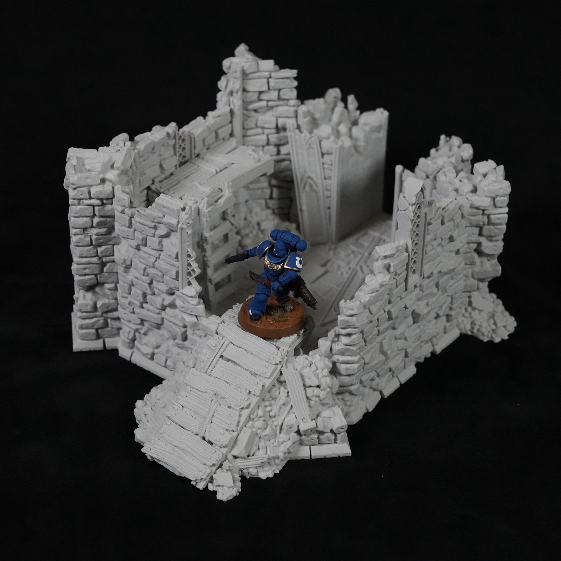 Grauer, steinerner Turm mit zerfallenen Mauern und Treppen, Miniaturfigur auf braunem Sockel.