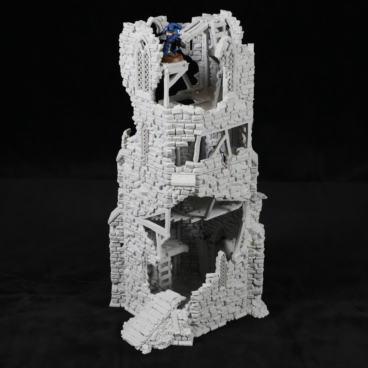 Grauer, mehrstöckiger Turm mit zerfallener Steinstruktur und innerer Wendeltreppe aus Holz.