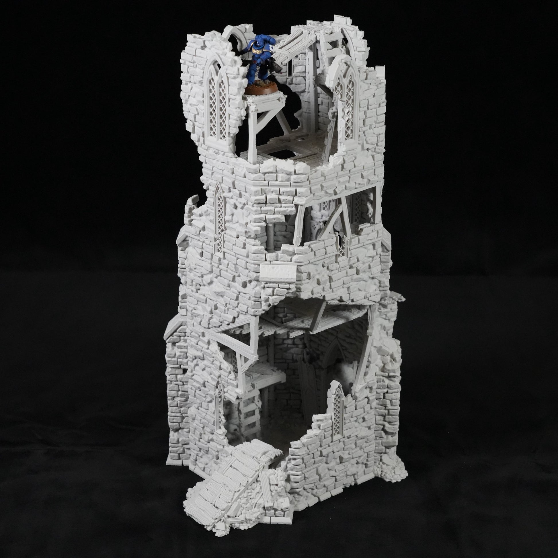 Grauer, mehrstöckiger Turm mit zerfallener Steinstruktur und innerer Wendeltreppe aus Holz.