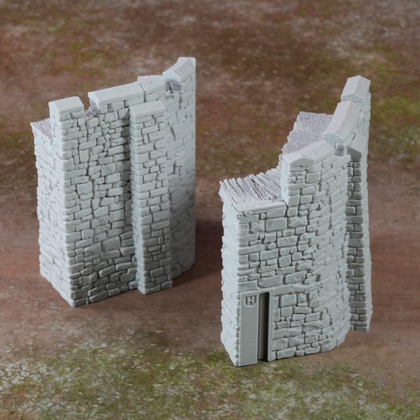 Zwei graue Miniatur-Burgmauern mit steiniger Struktur und turmartigem Design, kleinformatig.