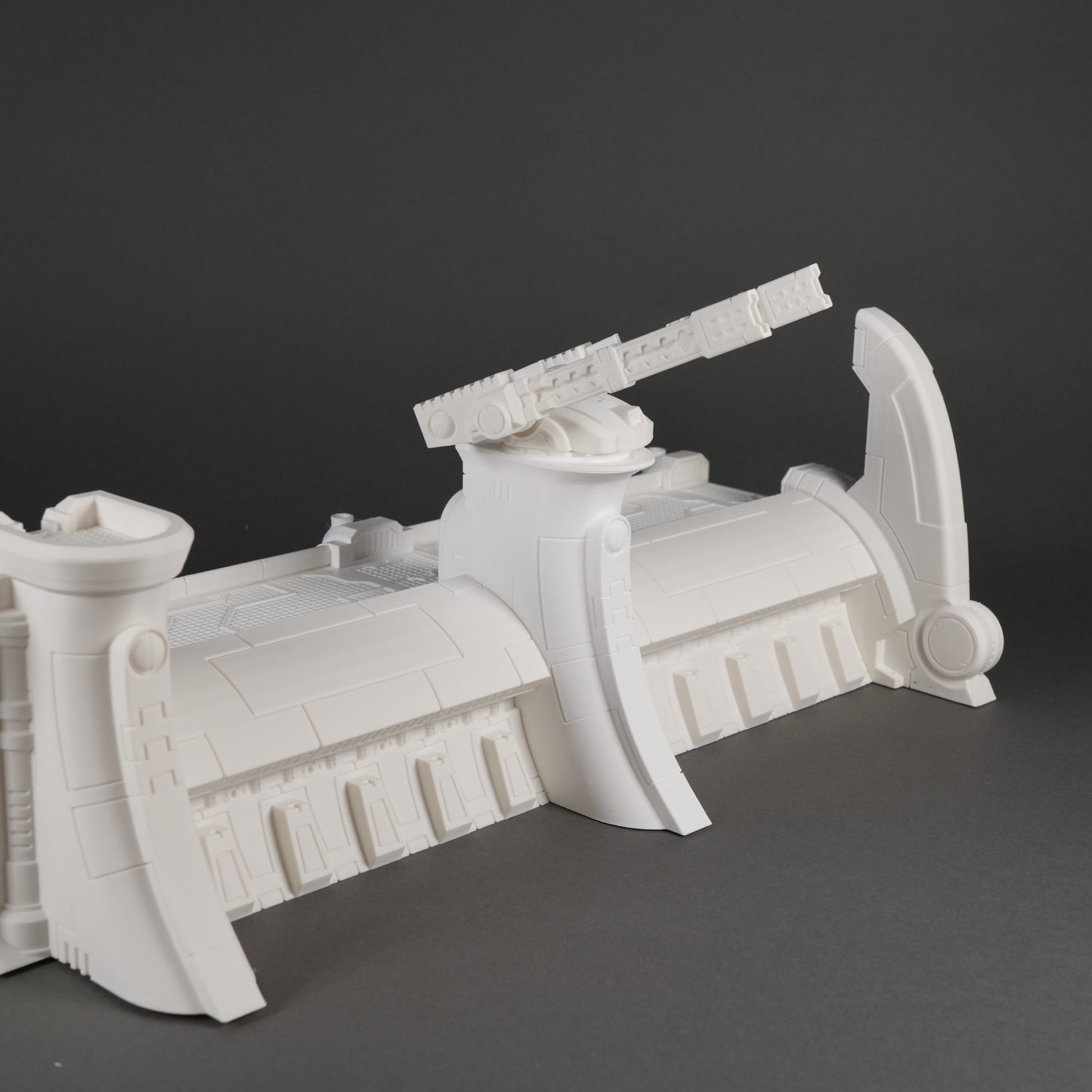 Weiße modulares Abwehrmauer-Segment mit verstärktem mittlerem Turm und seitlichen Stützpfeilern.