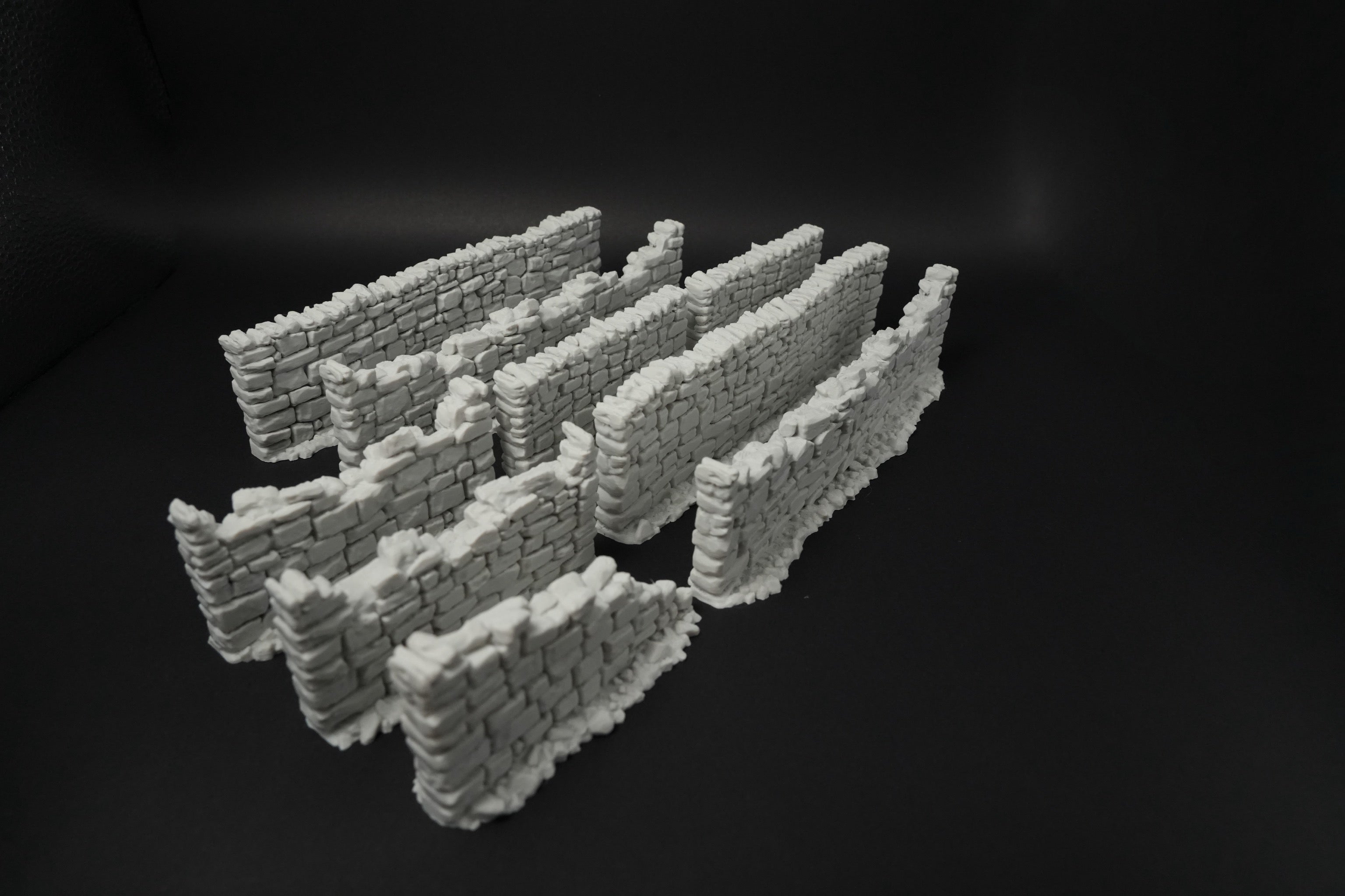 Mehrere hohe modulare Steinmauern in verschiedenen Längen und Grautönen, strukturierte Oberfläche.