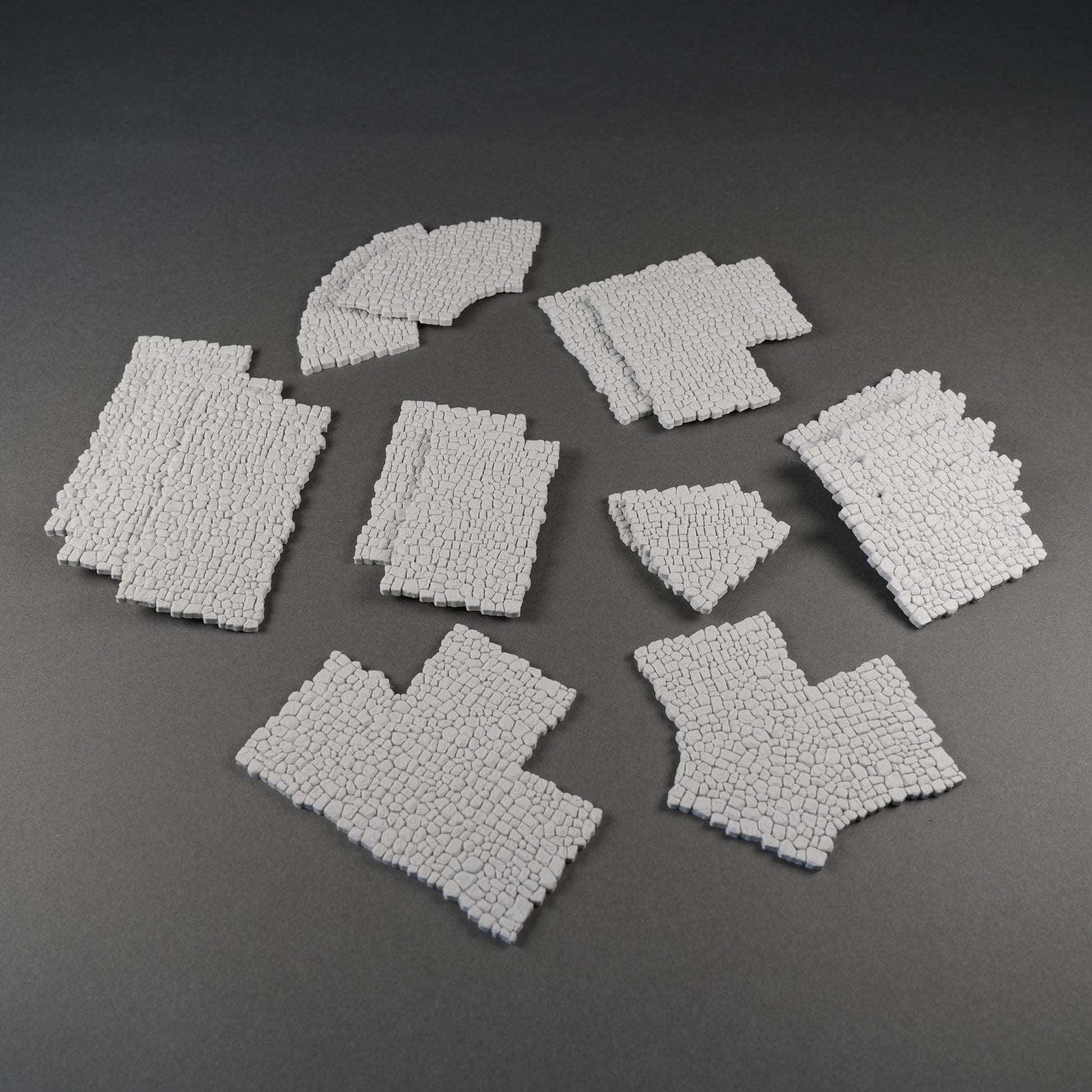 Modulare, graue Mauersegmente mit grober Steinstruktur für 28mm Geländebau, verschiedene Formen.