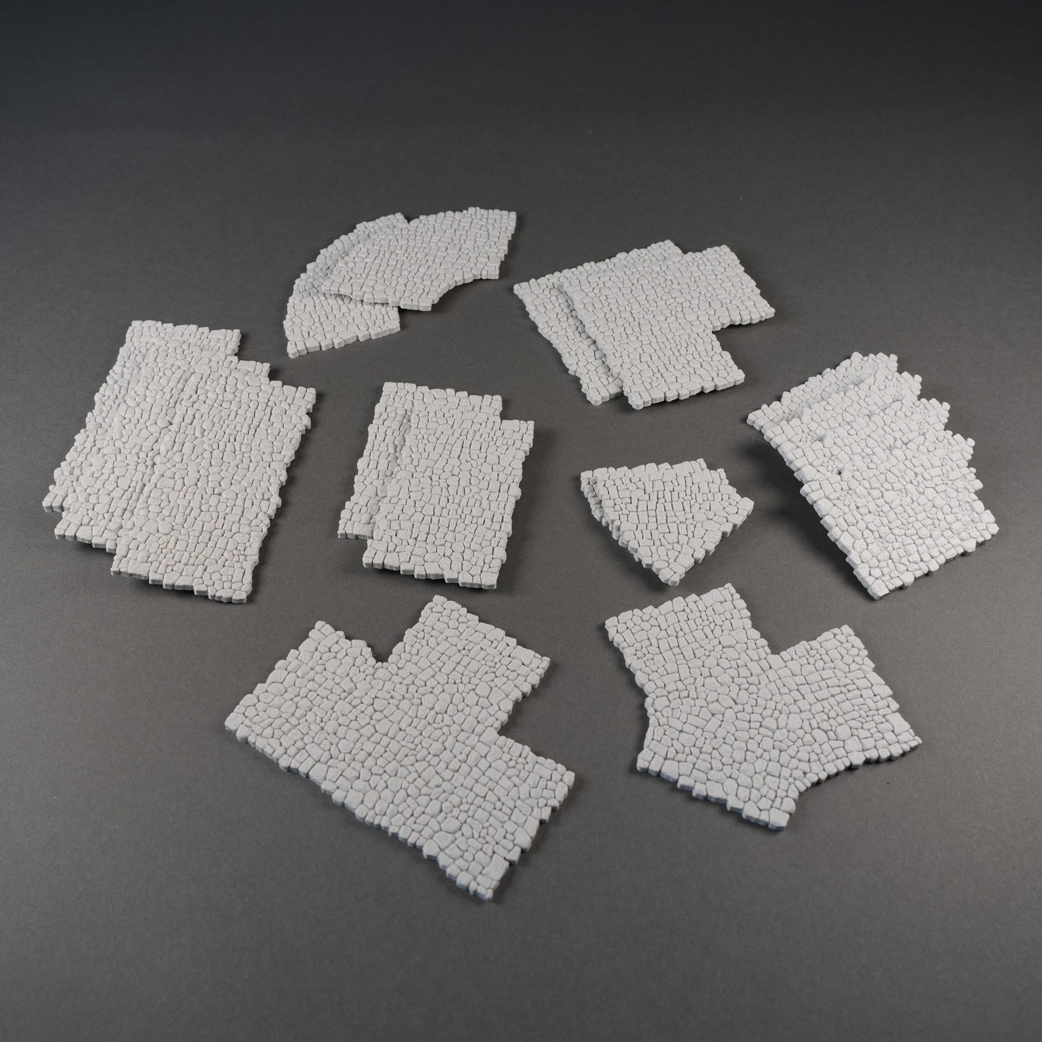 Modulare, graue Mauersegmente mit grober Steinstruktur für 28mm Geländebau, verschiedene Formen.
