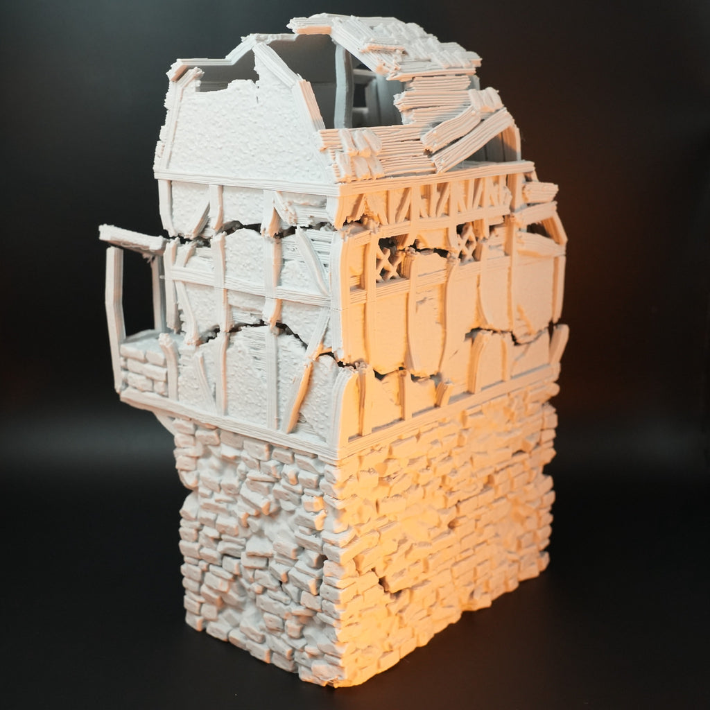 Zweiteiliger Torhausturm mit zerfallendem Fachwerk und bröckelndem Steinmauerwerk in hellem Grau.