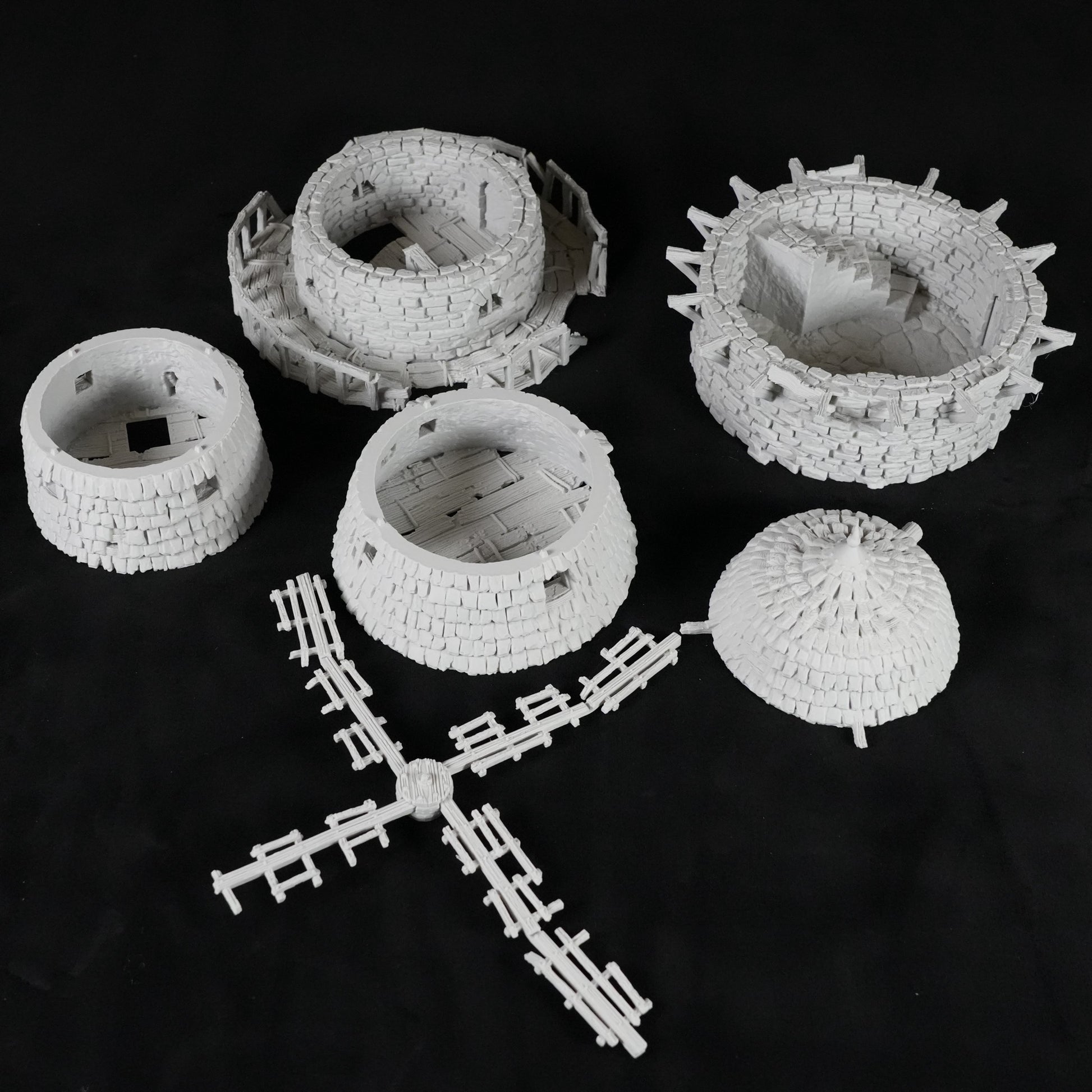 Weiße, detaillierte Miniaturmodelle einer verfluchten Windmühle mit Turm, Windmühlenflügeln und Rundmauerwerk.